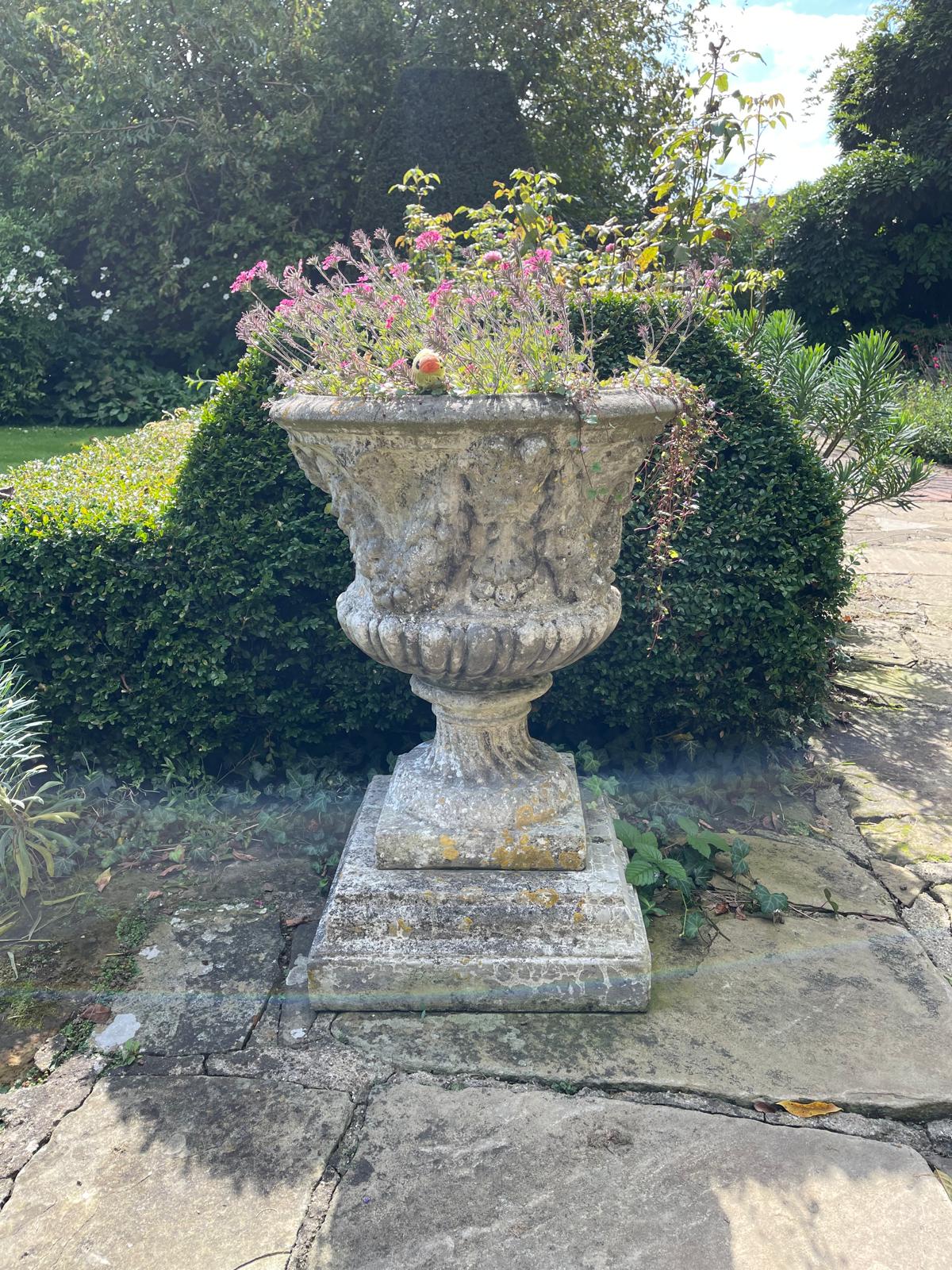 Three reconstituted stone campana shaped garden urns